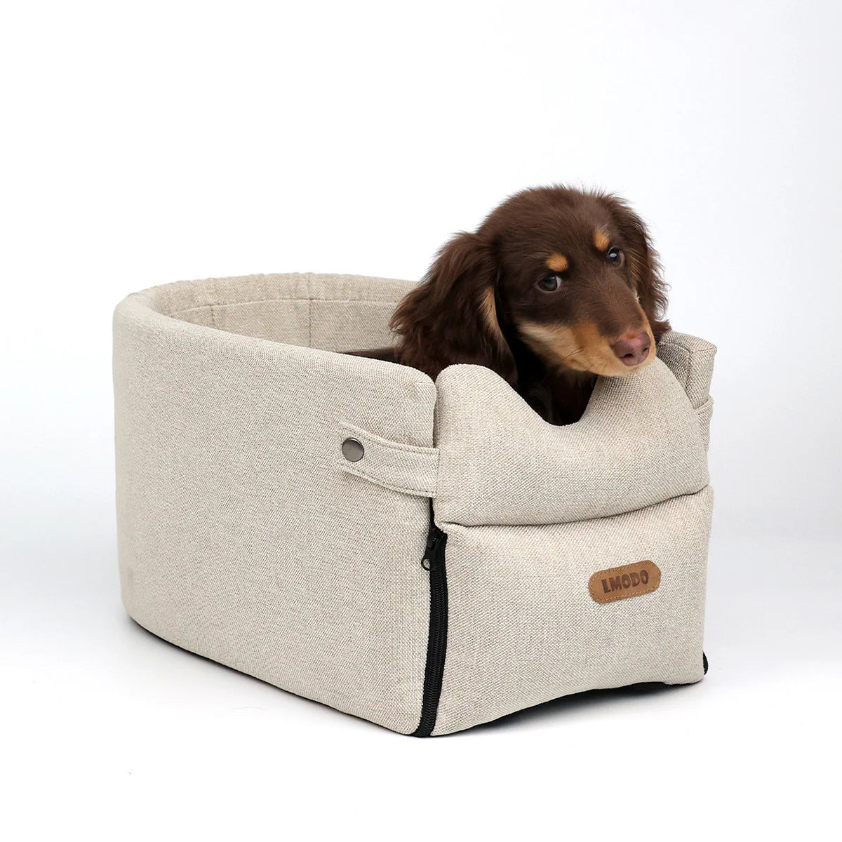 “Small brown dog sitting in a luxury beige portable pet car seat bed with safety design”