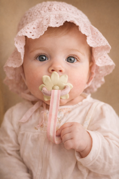 Baby holding LuxeBloom silicone baby teether in Beige Bloom