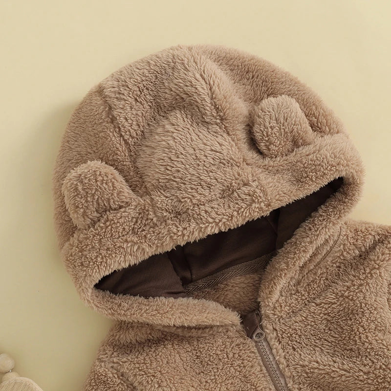 Close-up of bear ear hood on brown fuzzy baby romper