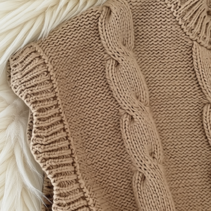 Close-up of light brown girls’ cable-knit vest texture and ribbed trim