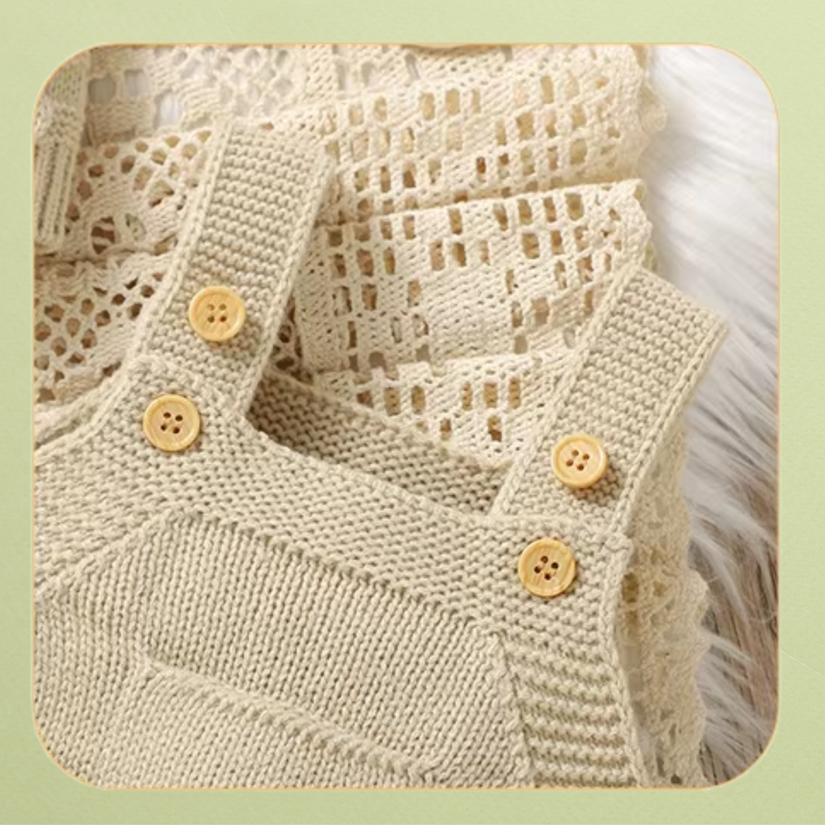 Close-up of cream knit baby overalls shoulder straps with wooden button details