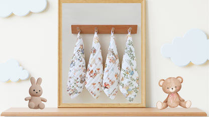“Luxury muslin baby burp cloths in whimsical woodland prints, displayed hanging on hooks with plush bunny and teddy bear nursery decor – soft 6-layer cotton gauze gift set for newborns.”
