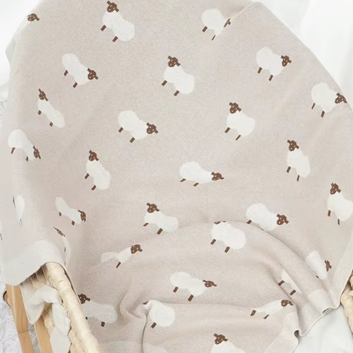 Oatmeal sheep baby blanket styled in nursery setting