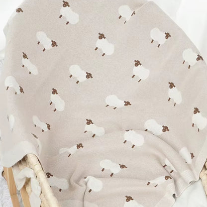 Oatmeal sheep baby blanket styled in nursery setting
