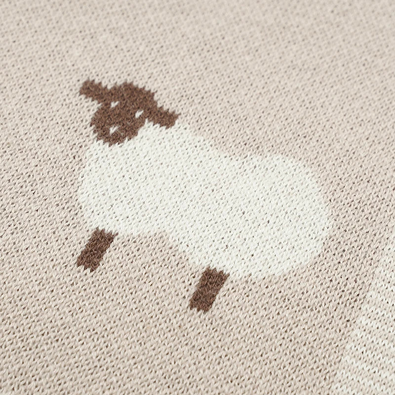Close-up of sheep pattern on knit baby blanket