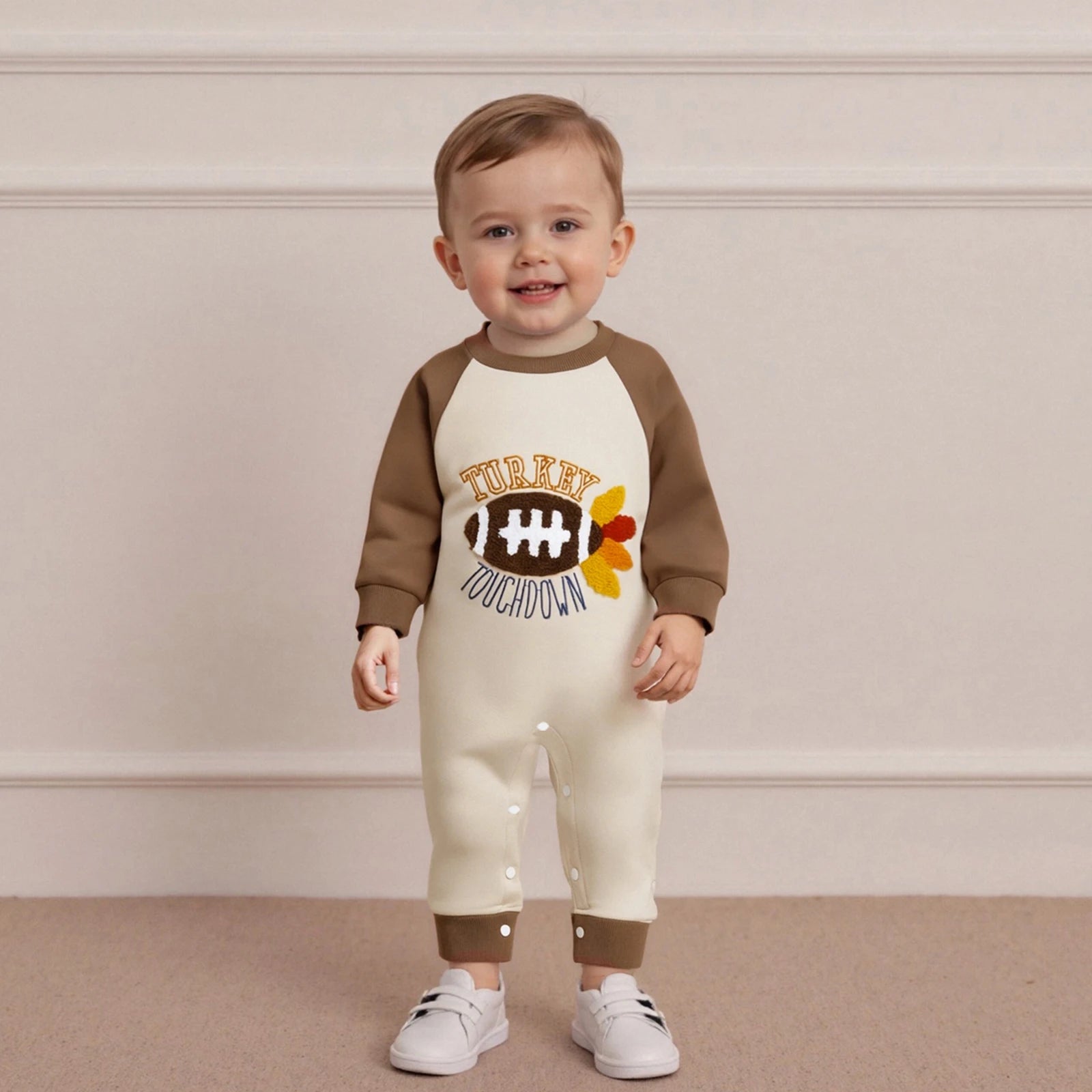 "Baby boy in Turkey Touchdown cotton romper, football-inspired Thanksgiving outfit"