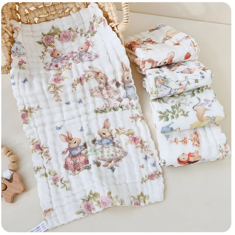 “Luxury muslin baby burp cloths in whimsical bunny and woodland prints, displayed with wicker basket and wooden teether – ultra-soft 6-layer cotton gauze, folded and laid flat for newborn essentials and gifting.”