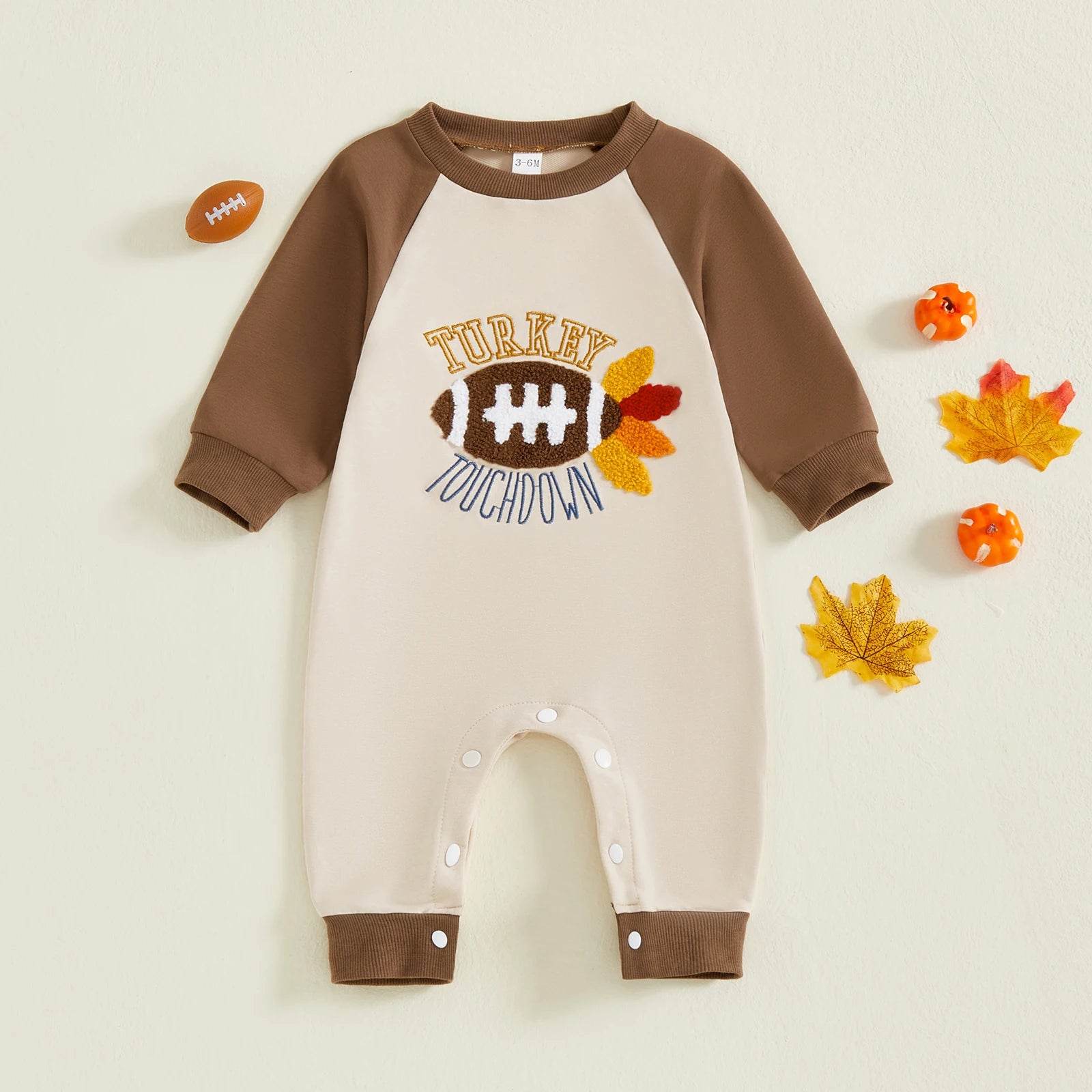 "Front view of brown and cream romper with turkey and football design, Thanksgiving babywear"