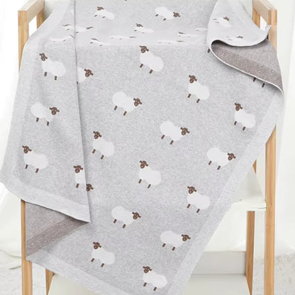 Gray sheep baby blanket draped over wooden display rack