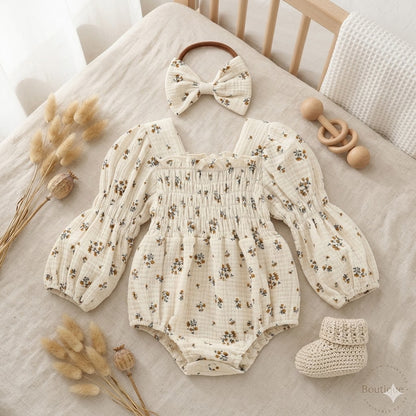 Cream bloom baby romper set with matching headband.