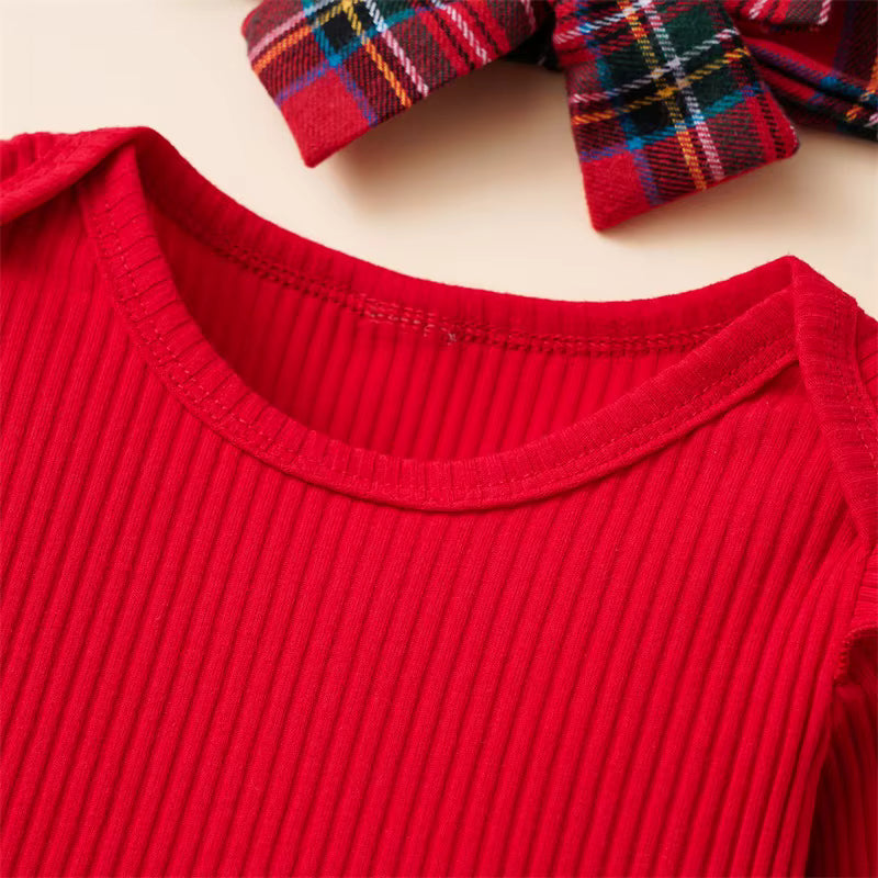 Close-up of red ribbed cotton baby romper neckline with plaid bow accessory — Christmas outfit detail.