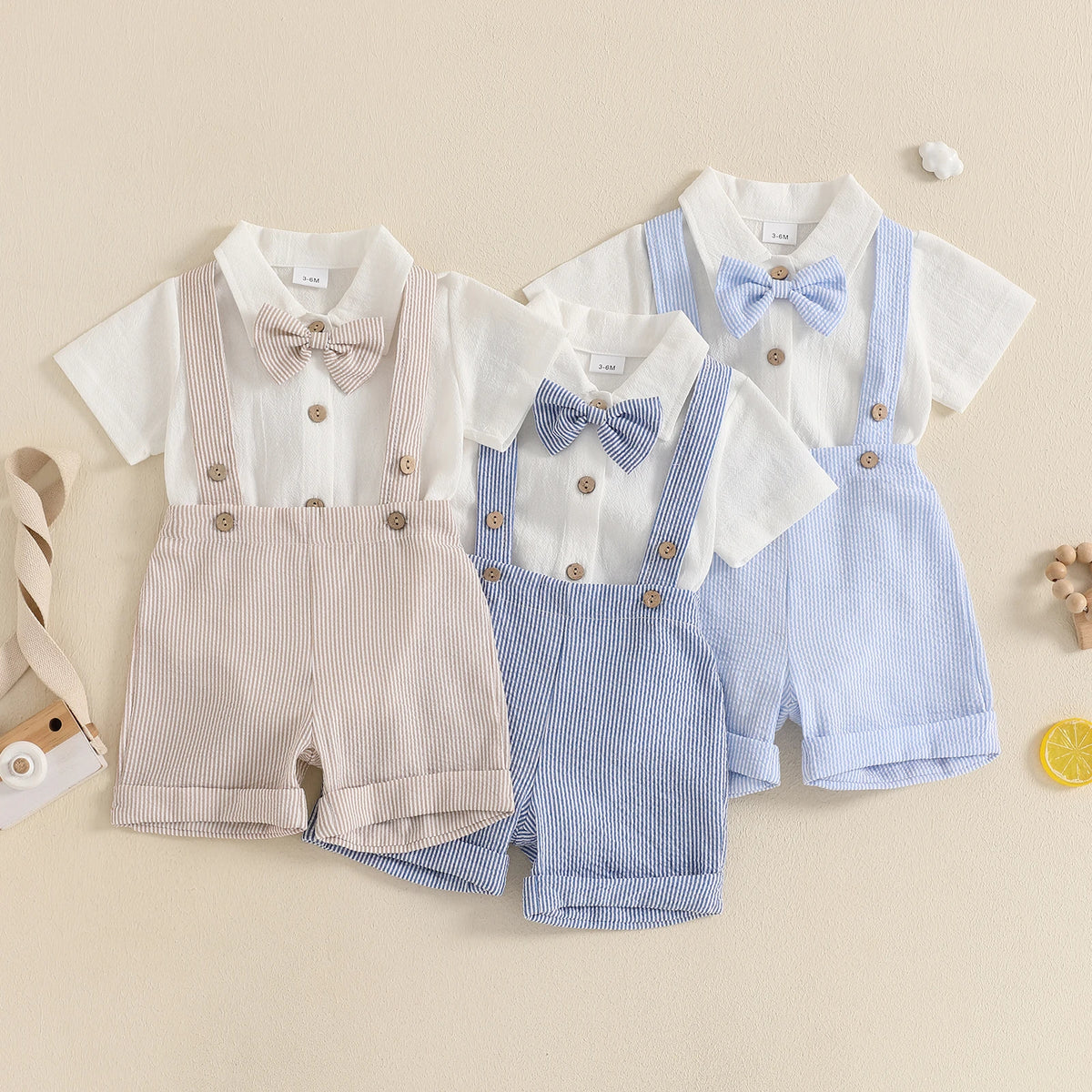 Three baby suspender romper sets in sand beige, classic blue, and powder blue white displayed on a light background.